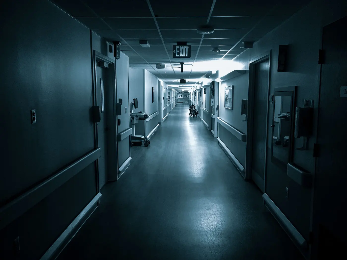 Stock photo: empty hospital corridor with an exit sign at the far end