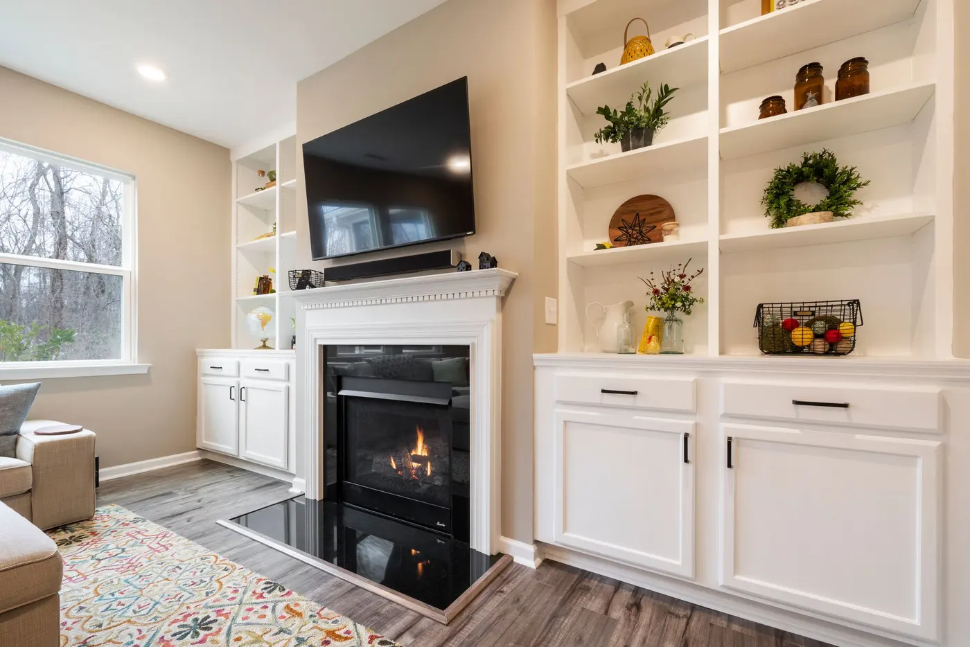 Stock photo: TV mounted above a fireplace between built in shelves