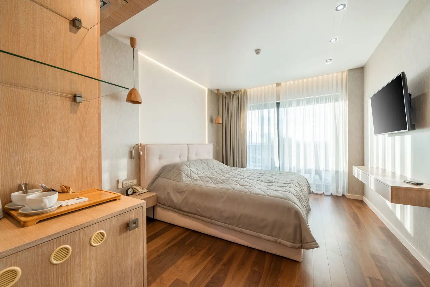 Stock photo: hotel room with a large wall mounted TV facing the bed