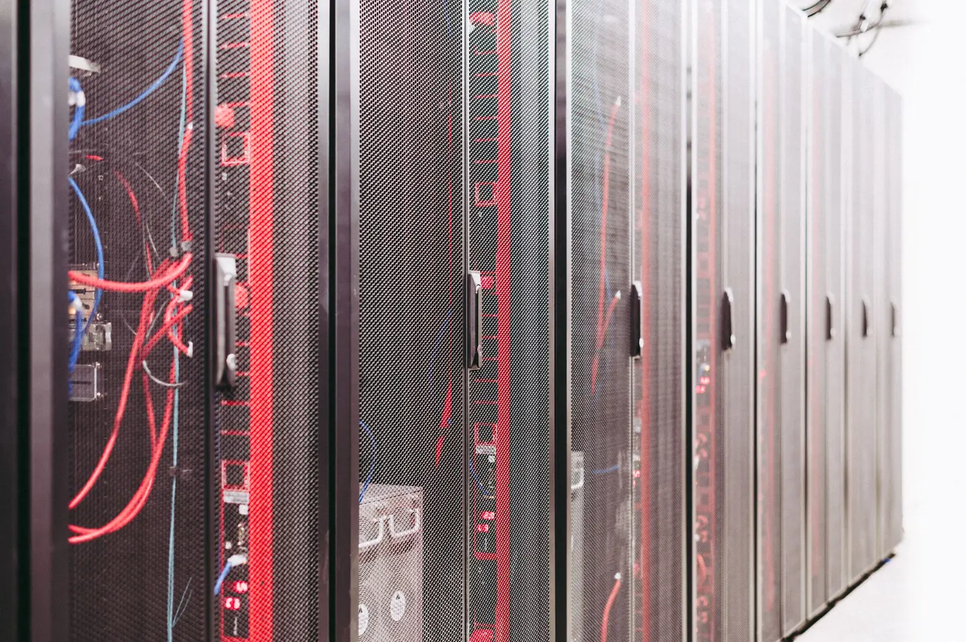 Stock photo: rows of dark equipment rack cabinets in a server room