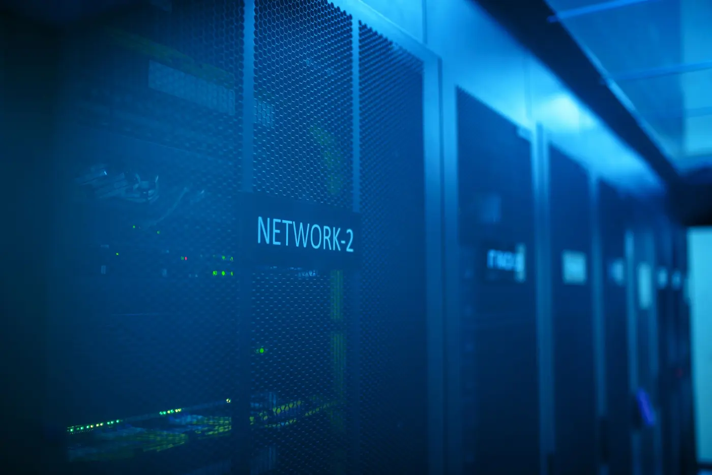 Stock photo: network equipment racks in a dark blue lit equipment room