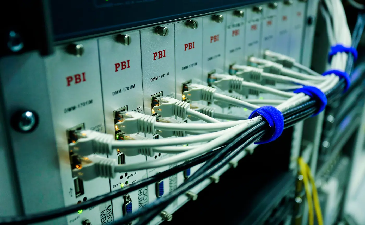 Stock photo: rack of TV headend modules with white patch cables dressed into a loom