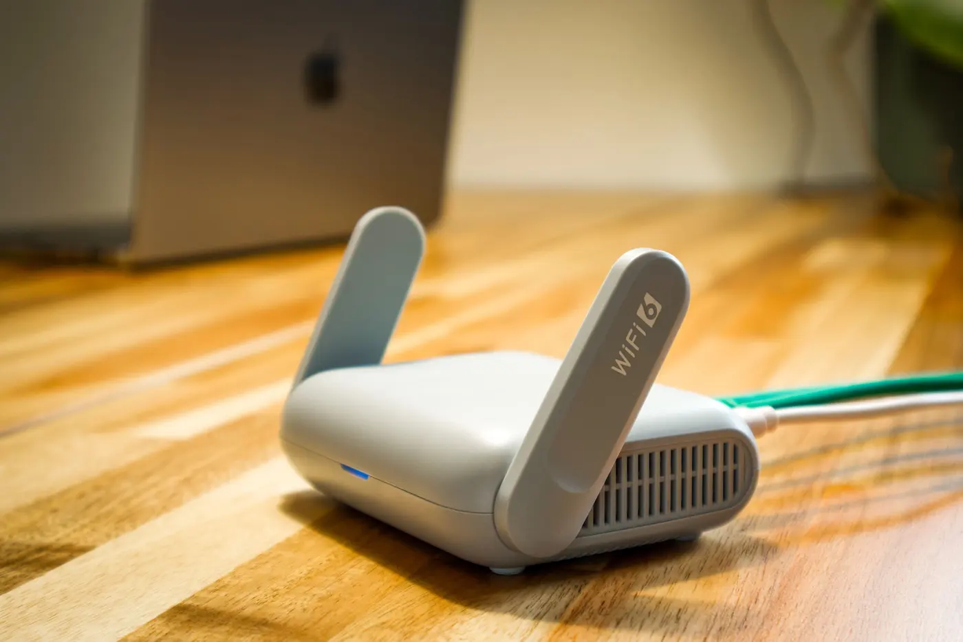 Stock photo: small WiFi access point with a network cable on a desk
